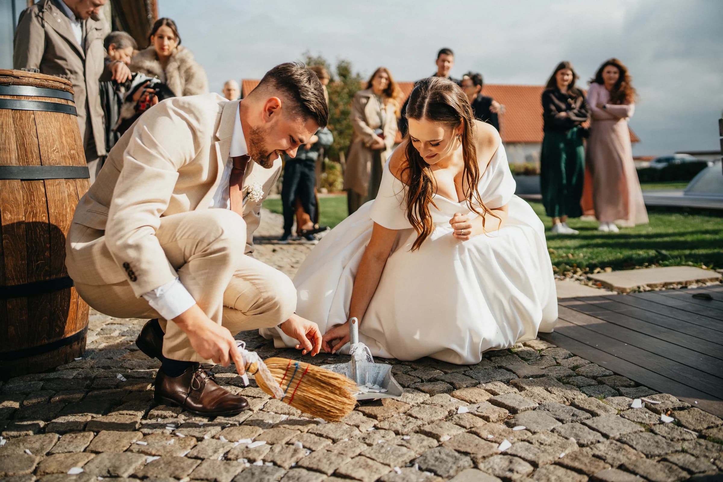 Novomanželé společně zametají střepy rozbitého talíře